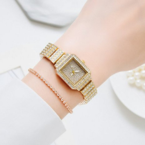 Luxusní dámské hodinky osázeny čirými kameny ve zlaté barvě, s náramkem